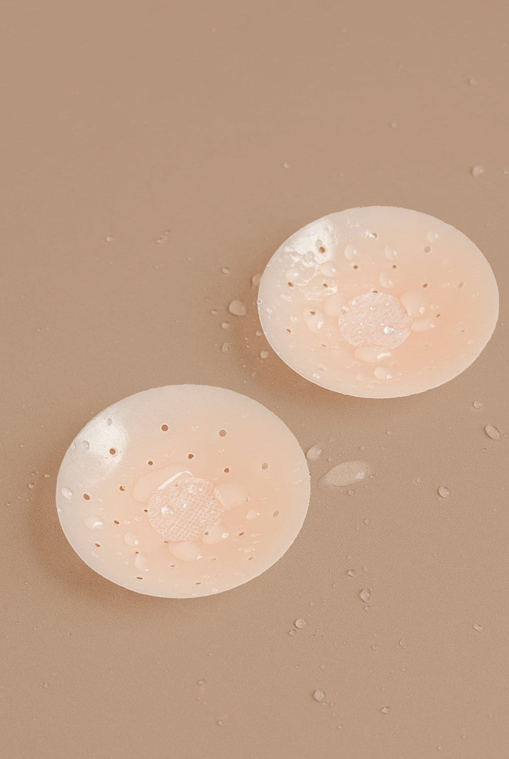 Nipple covers on brown background.