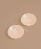 Nipple covers on brown background.
