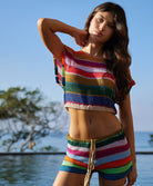 Woman wearing matching knit shirt and shorts in front of a pool.