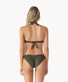 Blonde woman wearing a gray print halter bikini with ring detail facing backwards towards a white wall.