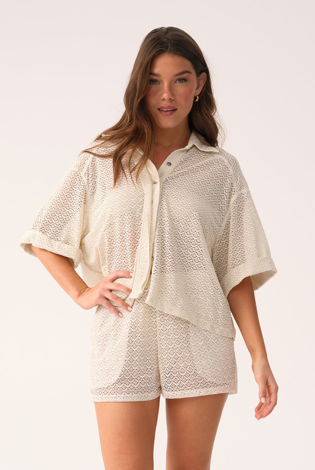 Woman wearing a beige lace outfit on a white background