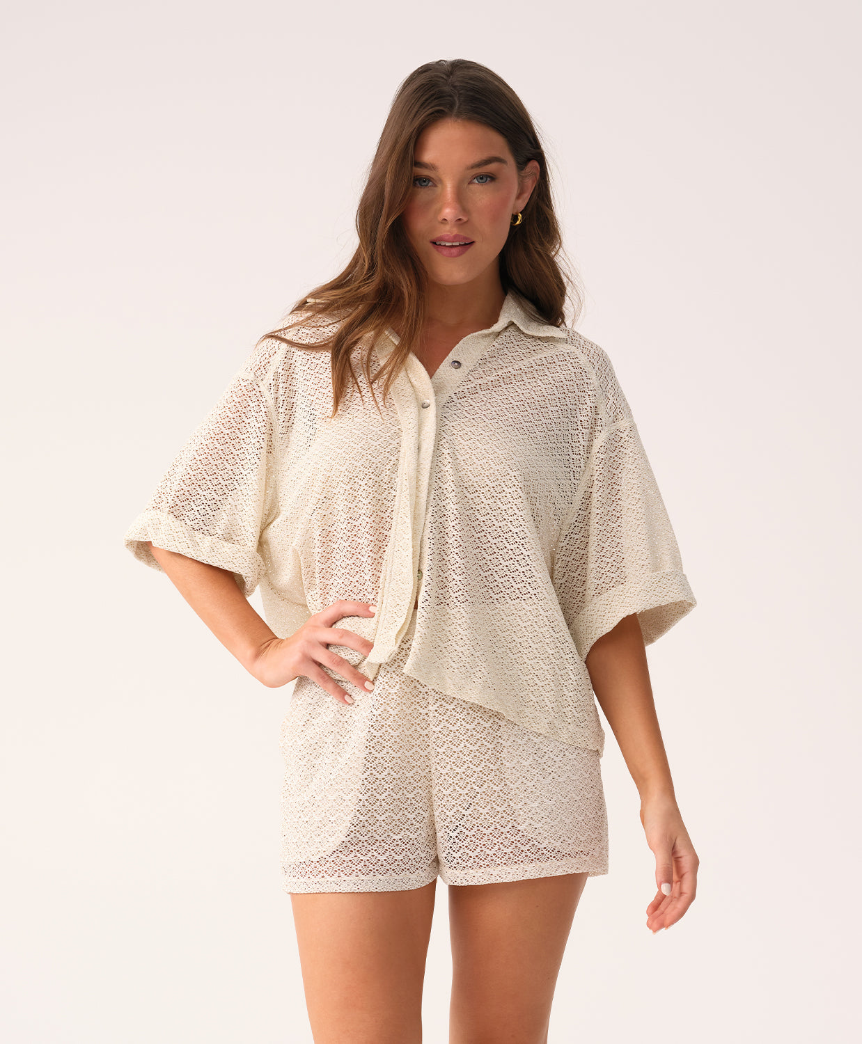 Woman wearing a beige lace outfit on a white background