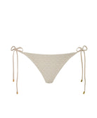 An ivory bikini bottom against a white wall.