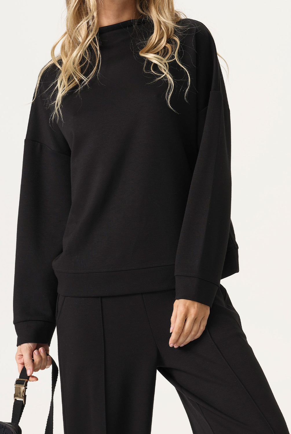 Woman wearing a black outfit with a plain background