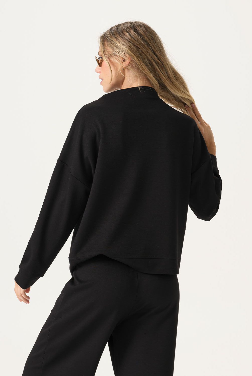 Woman wearing a black outfit on a plain background