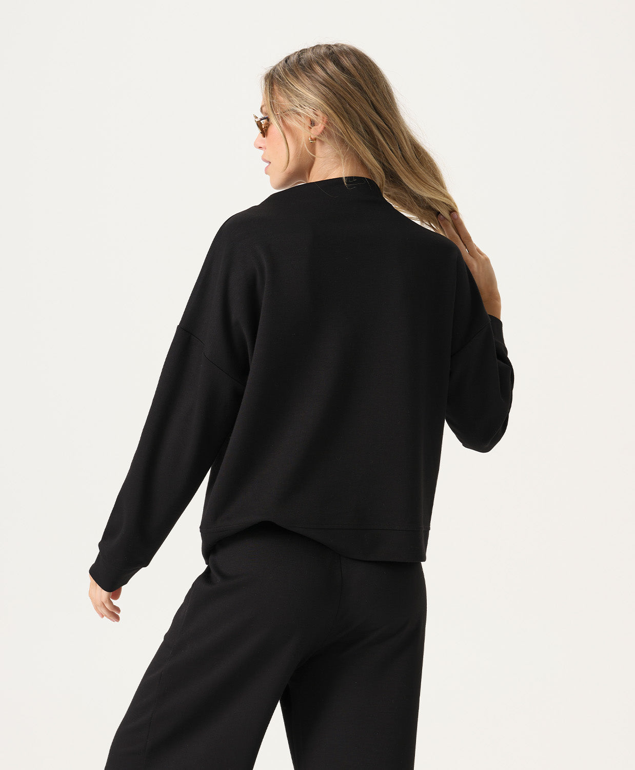 Woman wearing a black outfit on a plain background