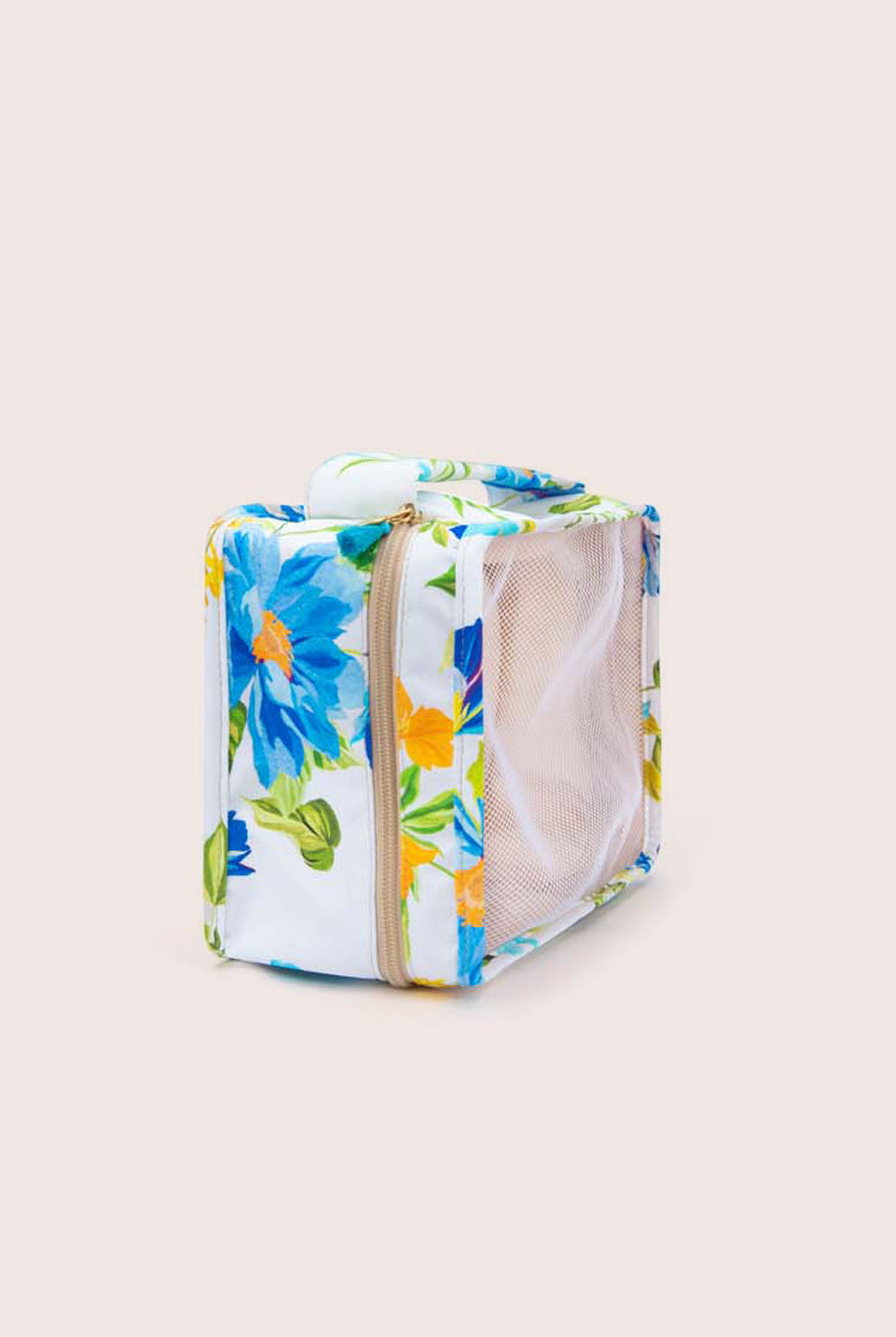 A packing cube with a floral print against a white wall.