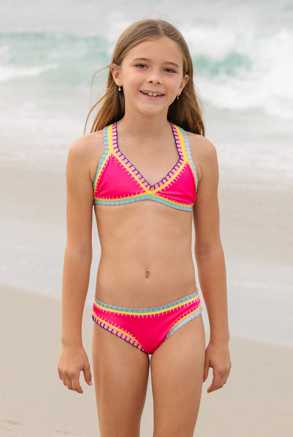 Young girl wearing a colorful bikini set on a beach