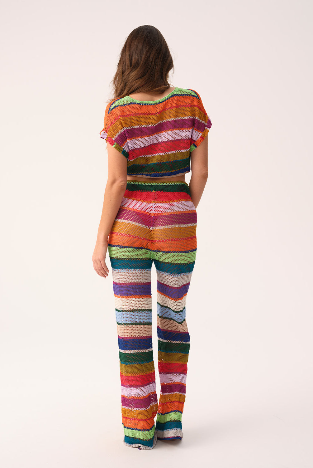 Woman wearing a colorful striped outfit on a white background