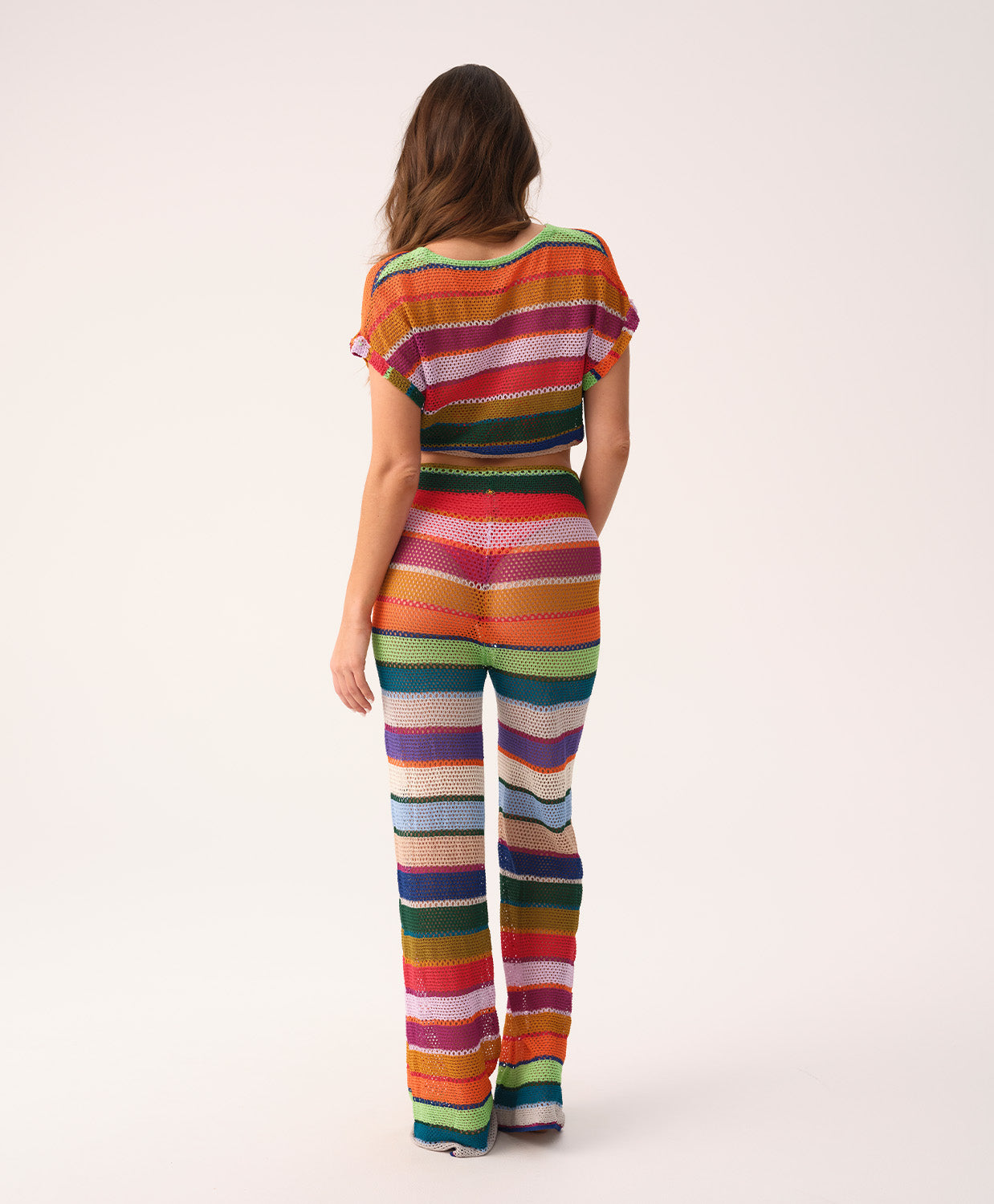 Woman wearing a colorful striped outfit on a white background