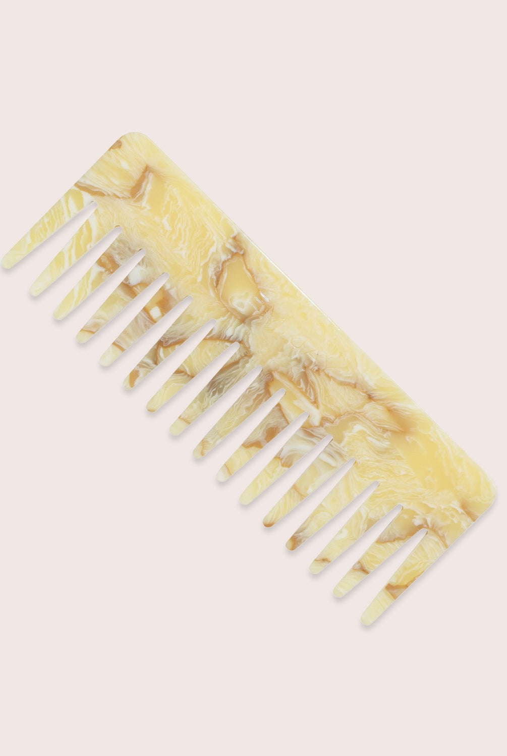 A yellow comb against a white wall.