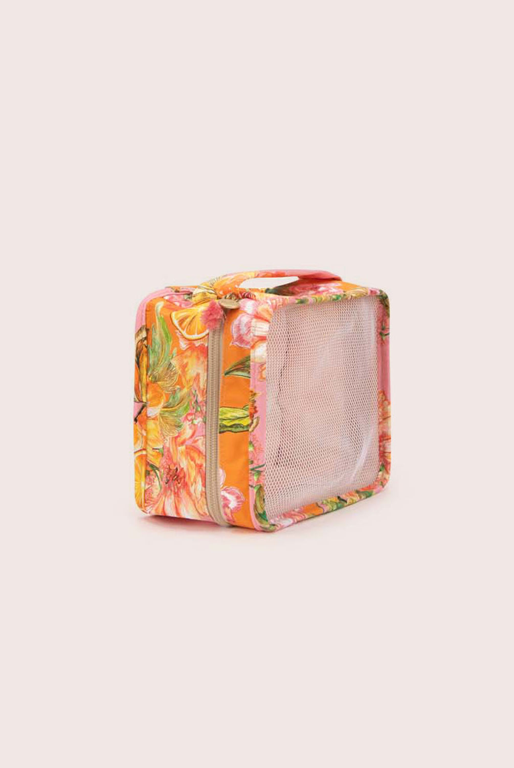 A packing cube with an orange floral print against a white wall.