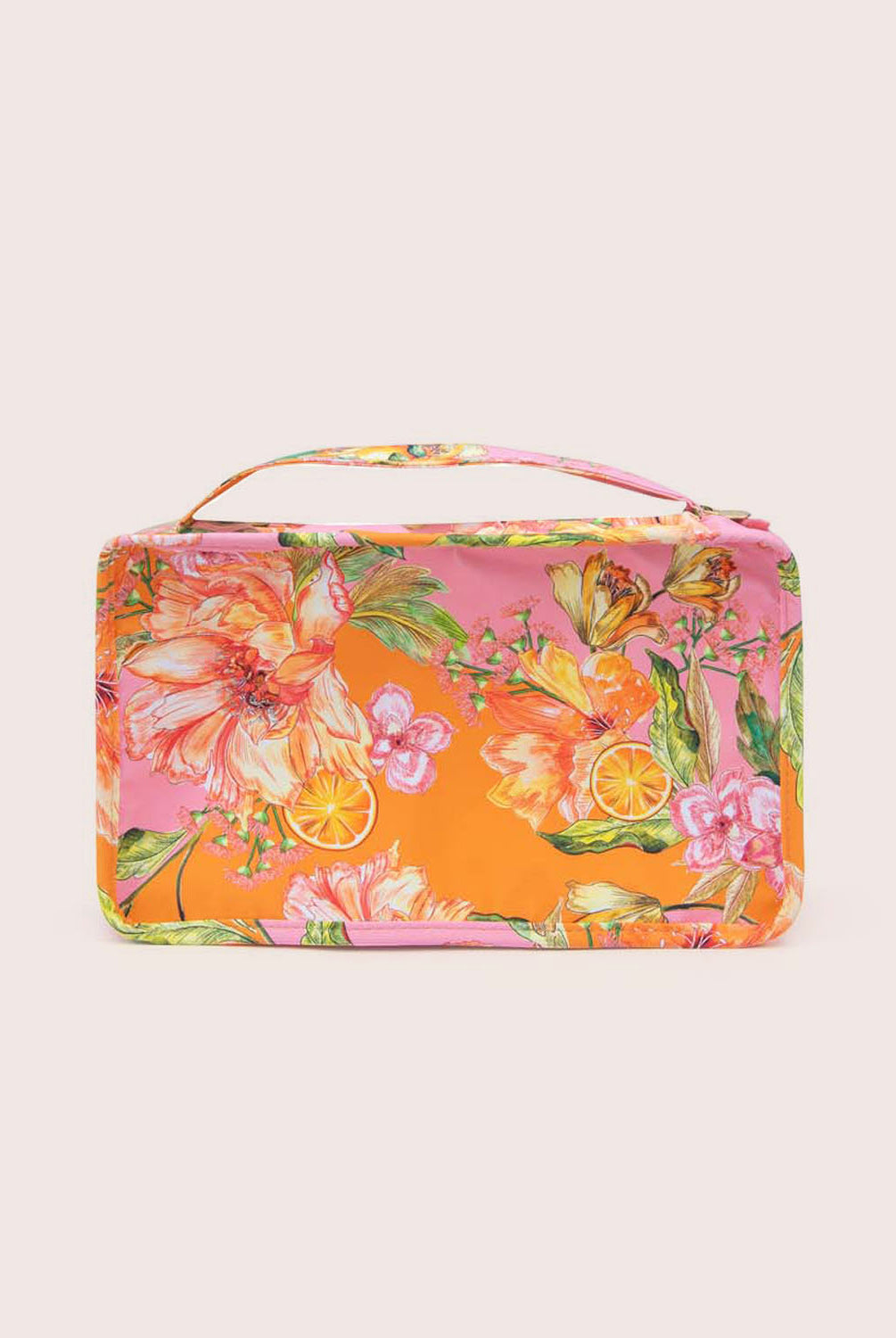 A packing cube with an orange floral print against a white wall.