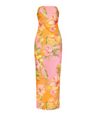 A long strapless pink and orange dress with a floral print against a white wall.