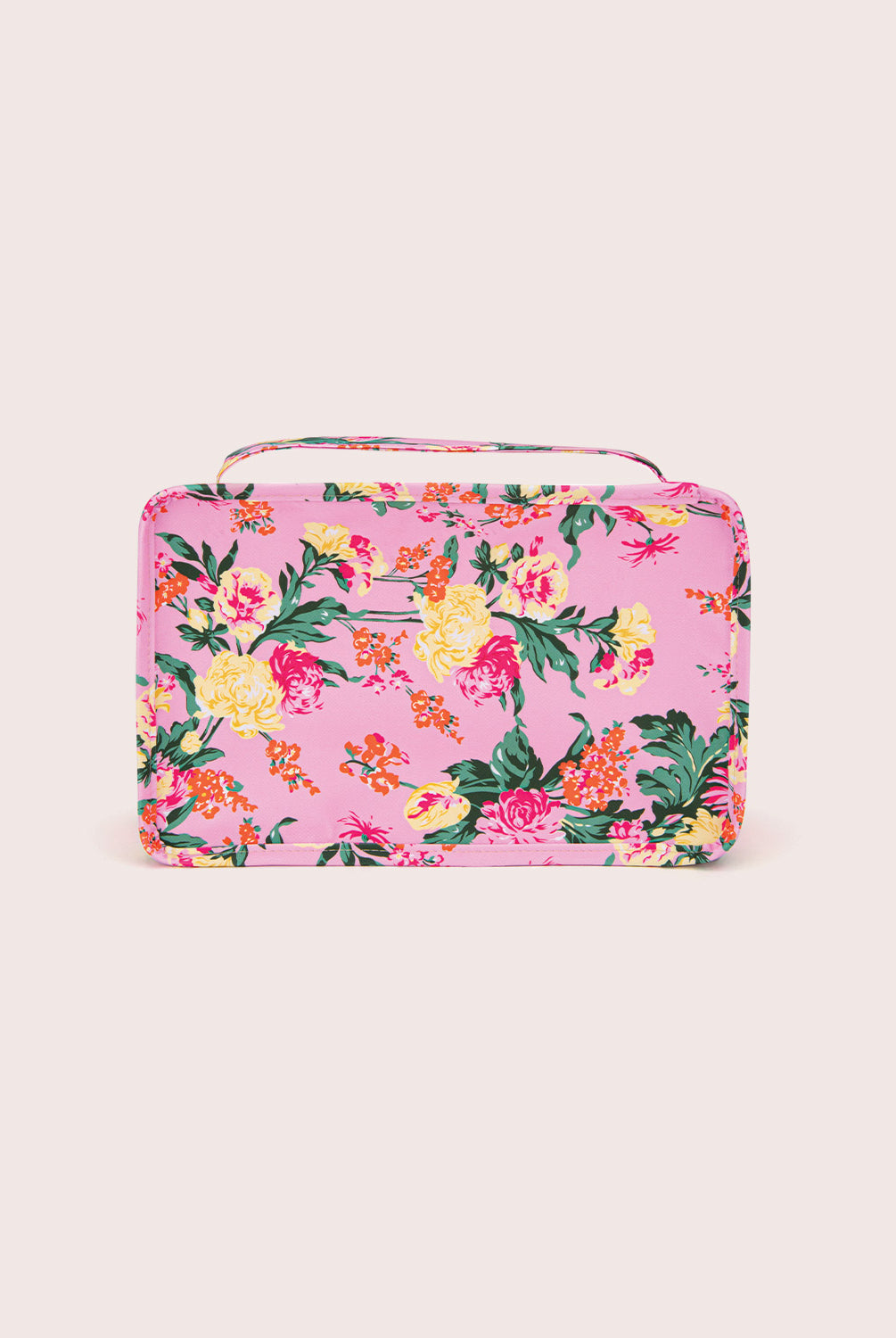 Floral-patterned pink packing cube on a light pink background
