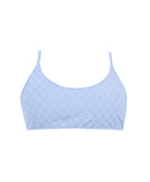 A blue bikini top against a white wall.