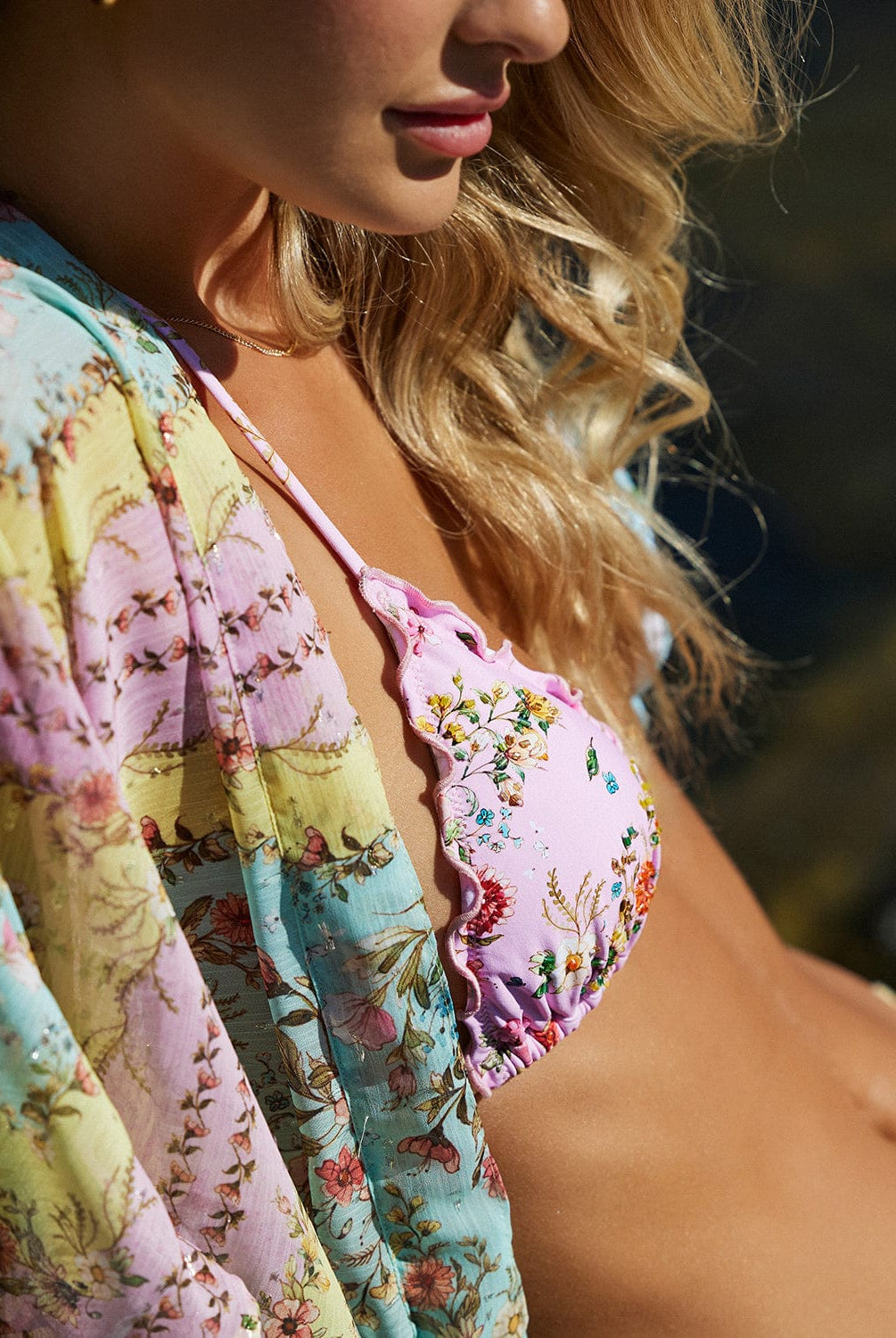A blonde woman wearing a floral bikini  & cover up.