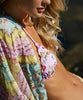 A blonde woman wearing a floral bikini  & cover up.