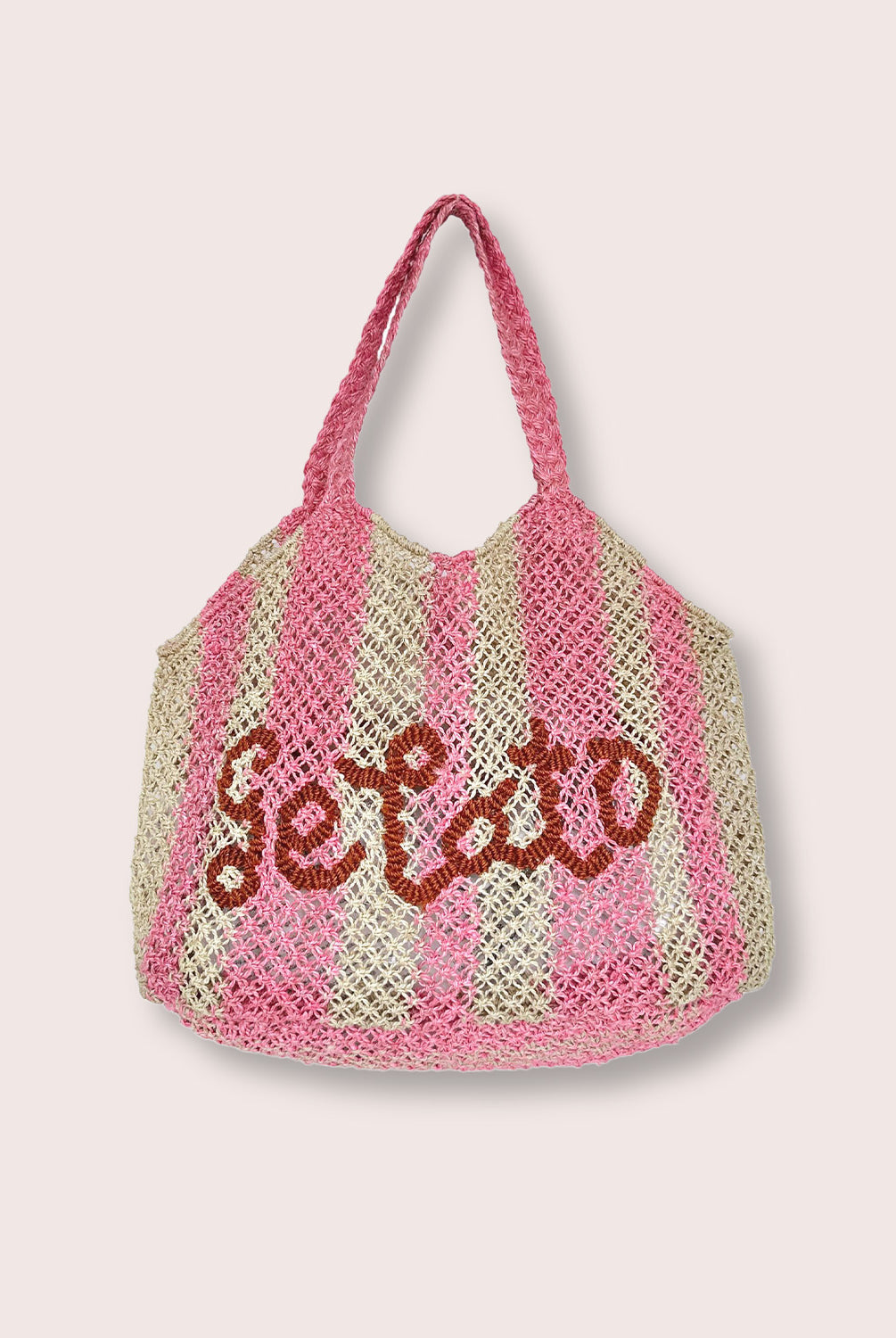 A pink striped purse/tote with letters that says "Gelato" against a white wall.