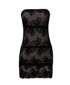 A mini strapless black dress against a white wall.