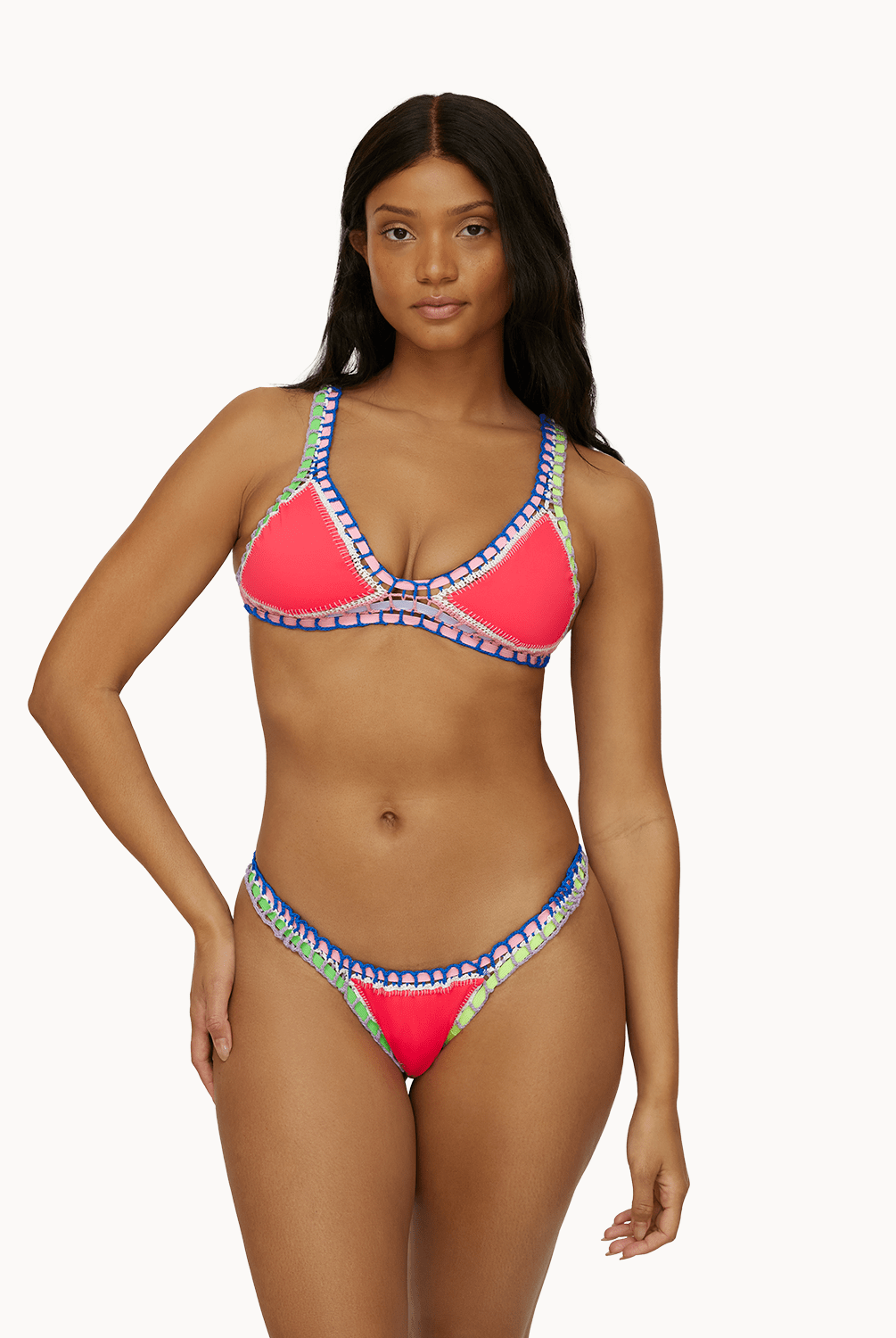 Woman wearing a red crochet bikini in front of a white background.