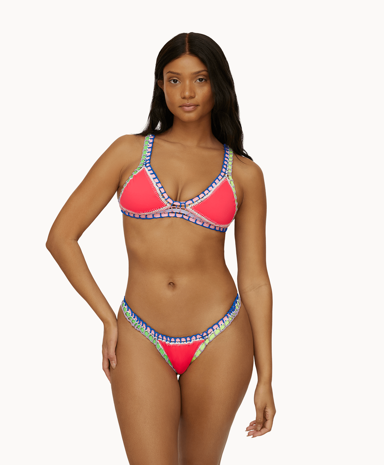 Woman wearing a red crochet bikini in front of a white background.