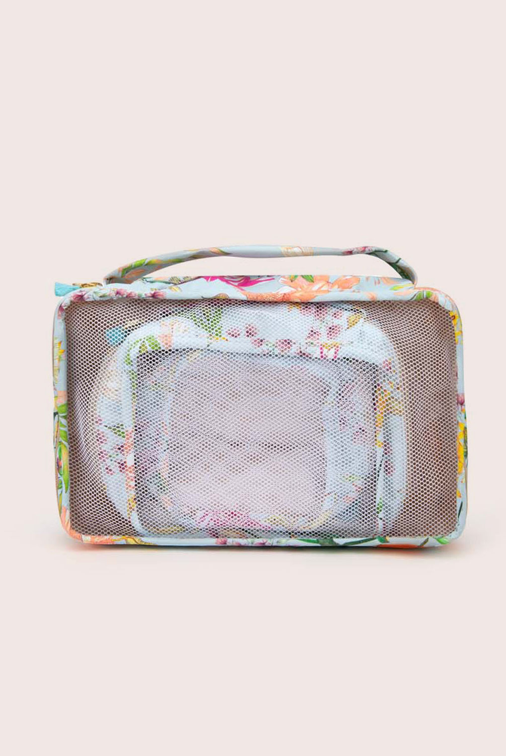 A set of packing cubes with blue floral fabric against a white wall.