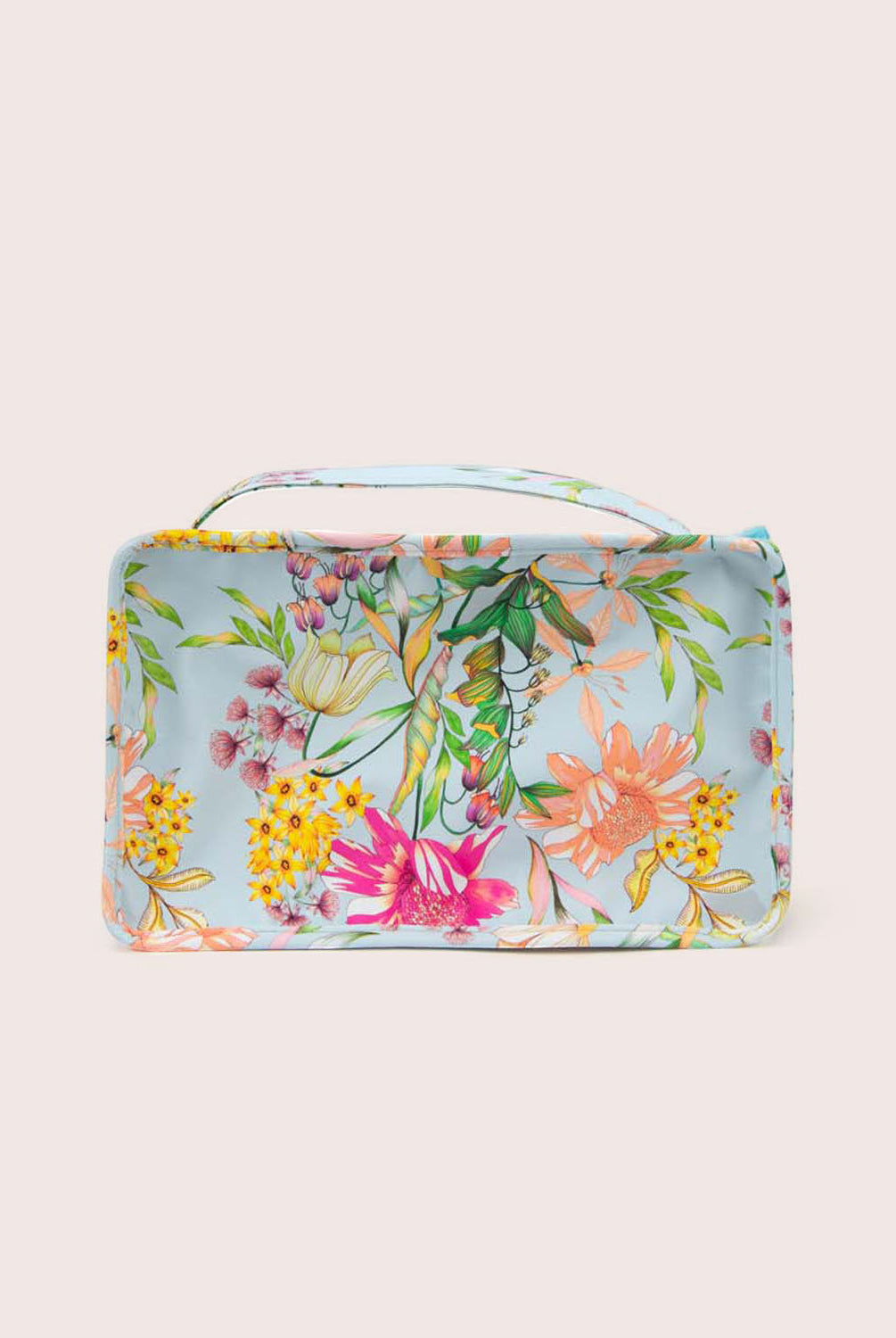 A packing cube with blue floral fabric against a white wall.