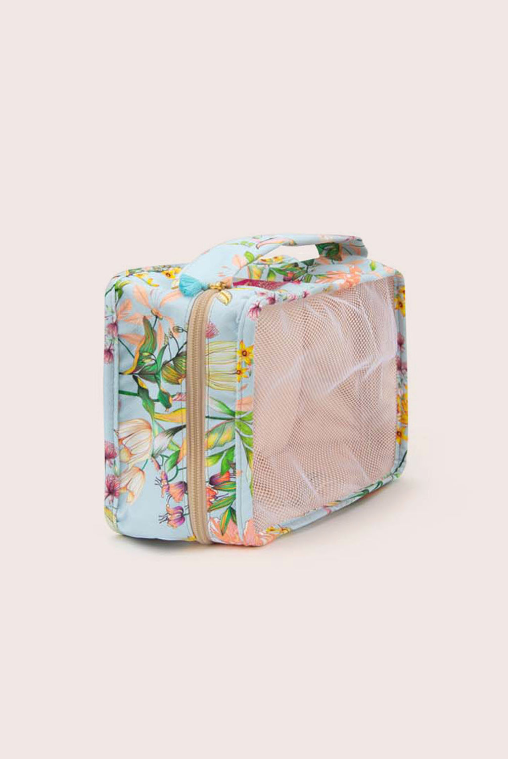 A packing cube with blue floral fabric against a white wall.