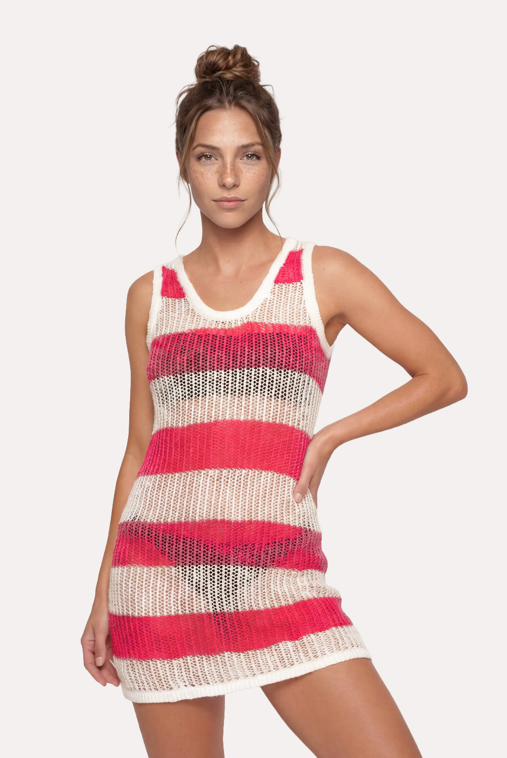 Woman wearing a pink and beige striped dress on a plain background
