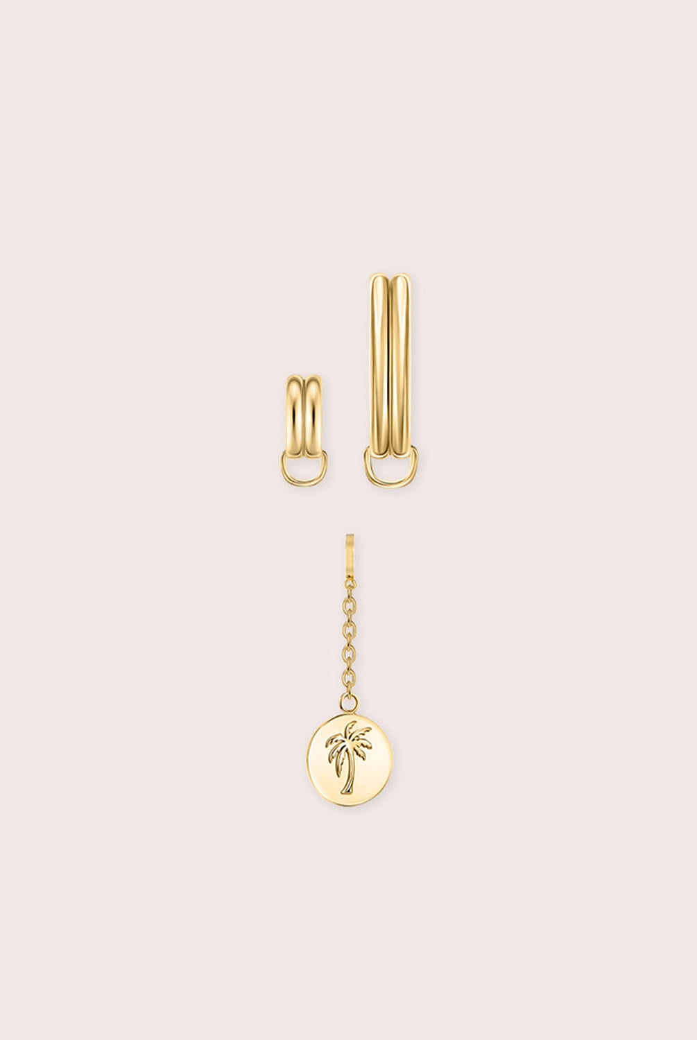 Gold jewelry piece with palm tree details against a white wall.
