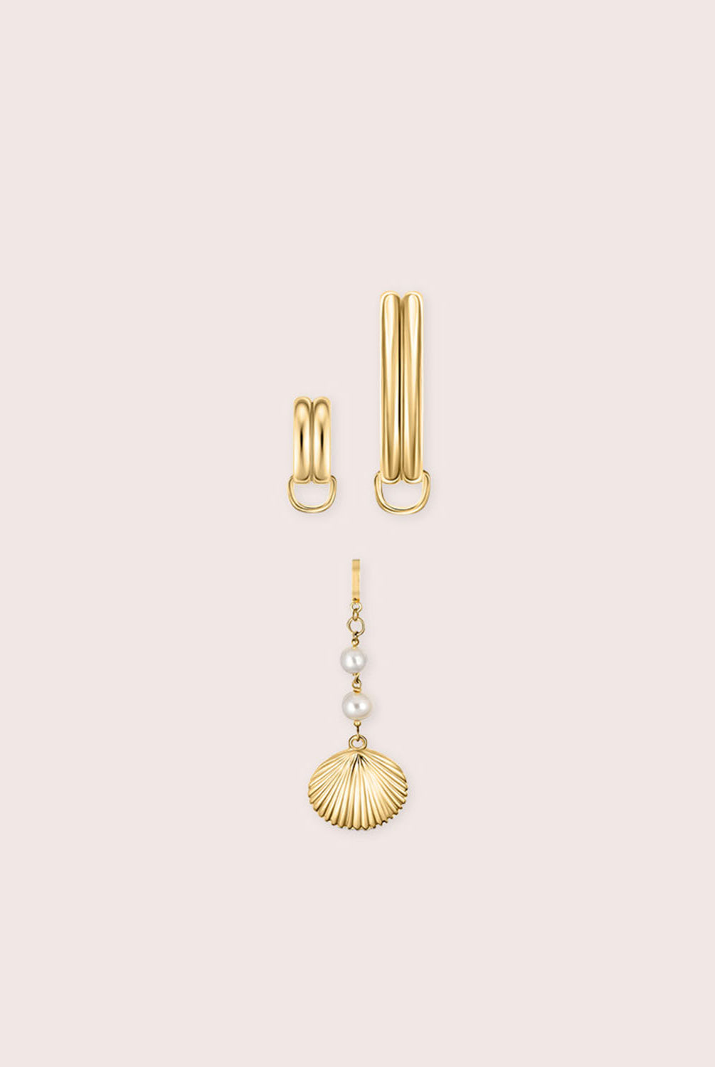 Gold bikini jewelry with a shell against a white wall.