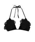 A black bikini triangle top against a white wall background.