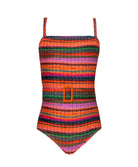 A multi colored striped one piece swimsuit against a white wall.