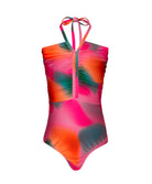 A pink tie dye one piece swimsuit against a white wall.