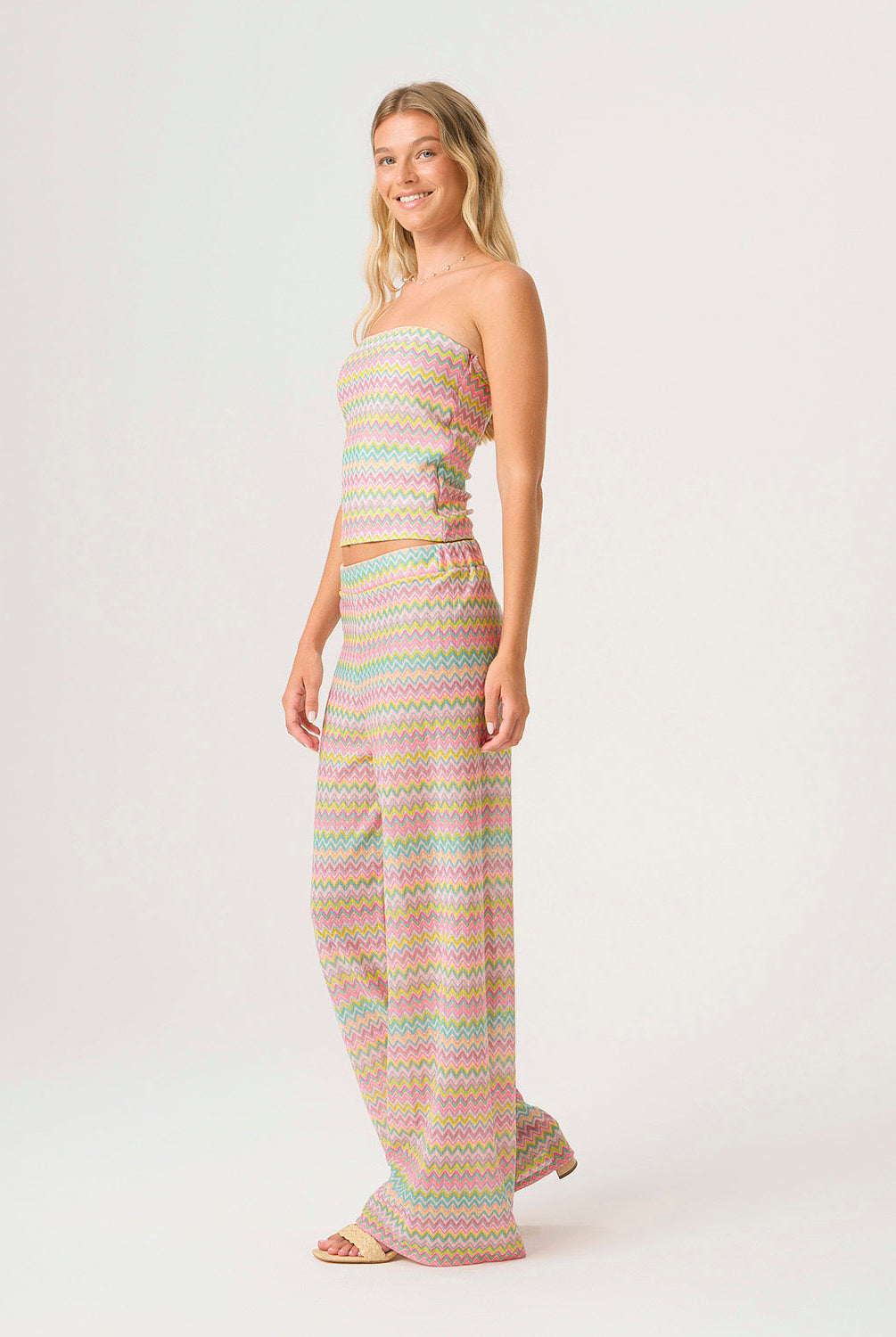 Woman wearing a pastel striped outfit on a white background