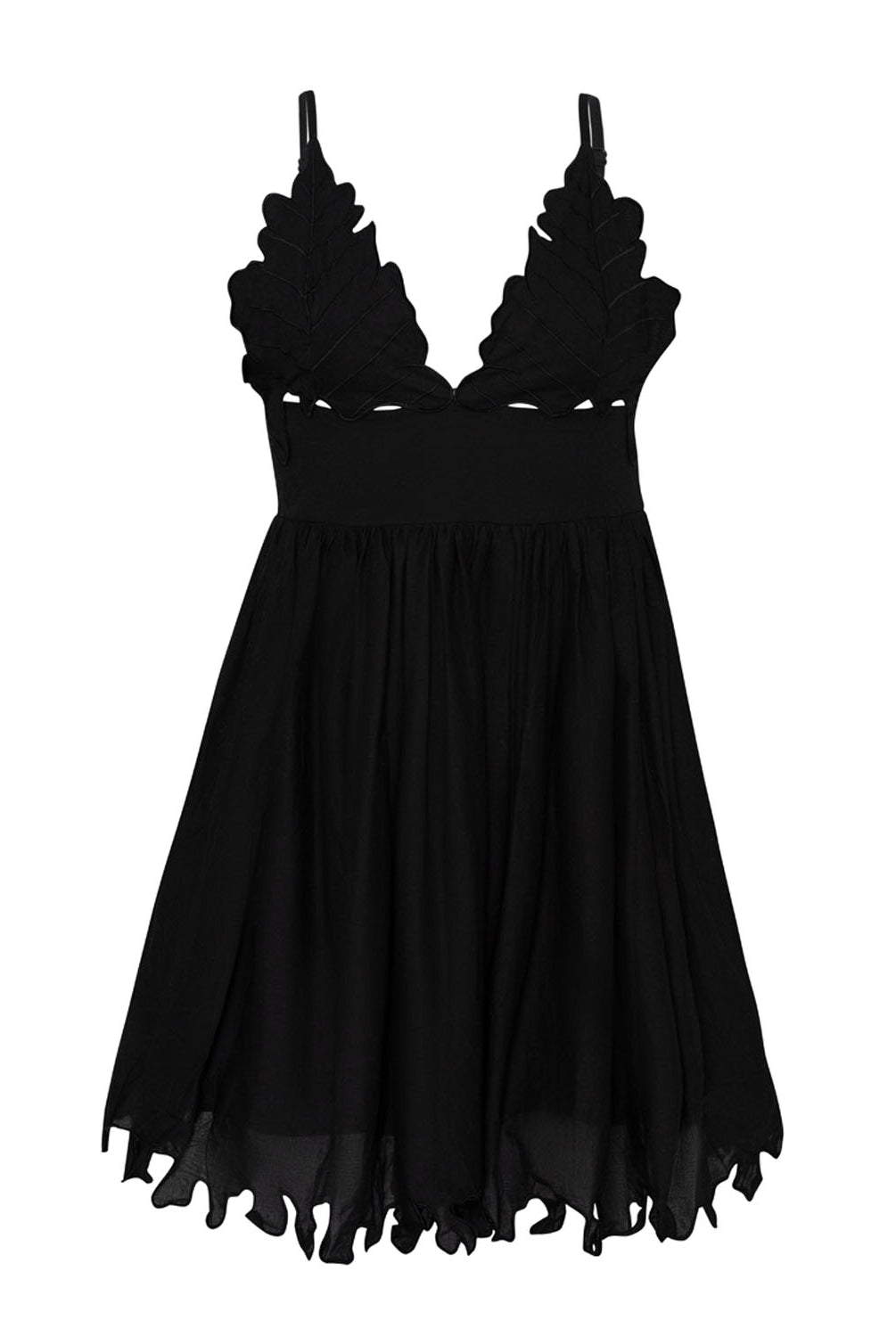 A short black dress against a white wall background.