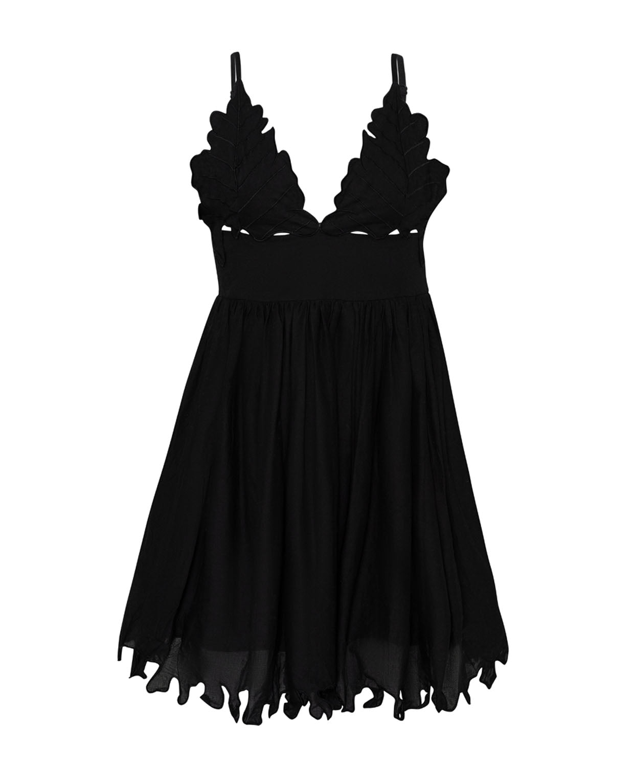 A short black dress against a white wall background.