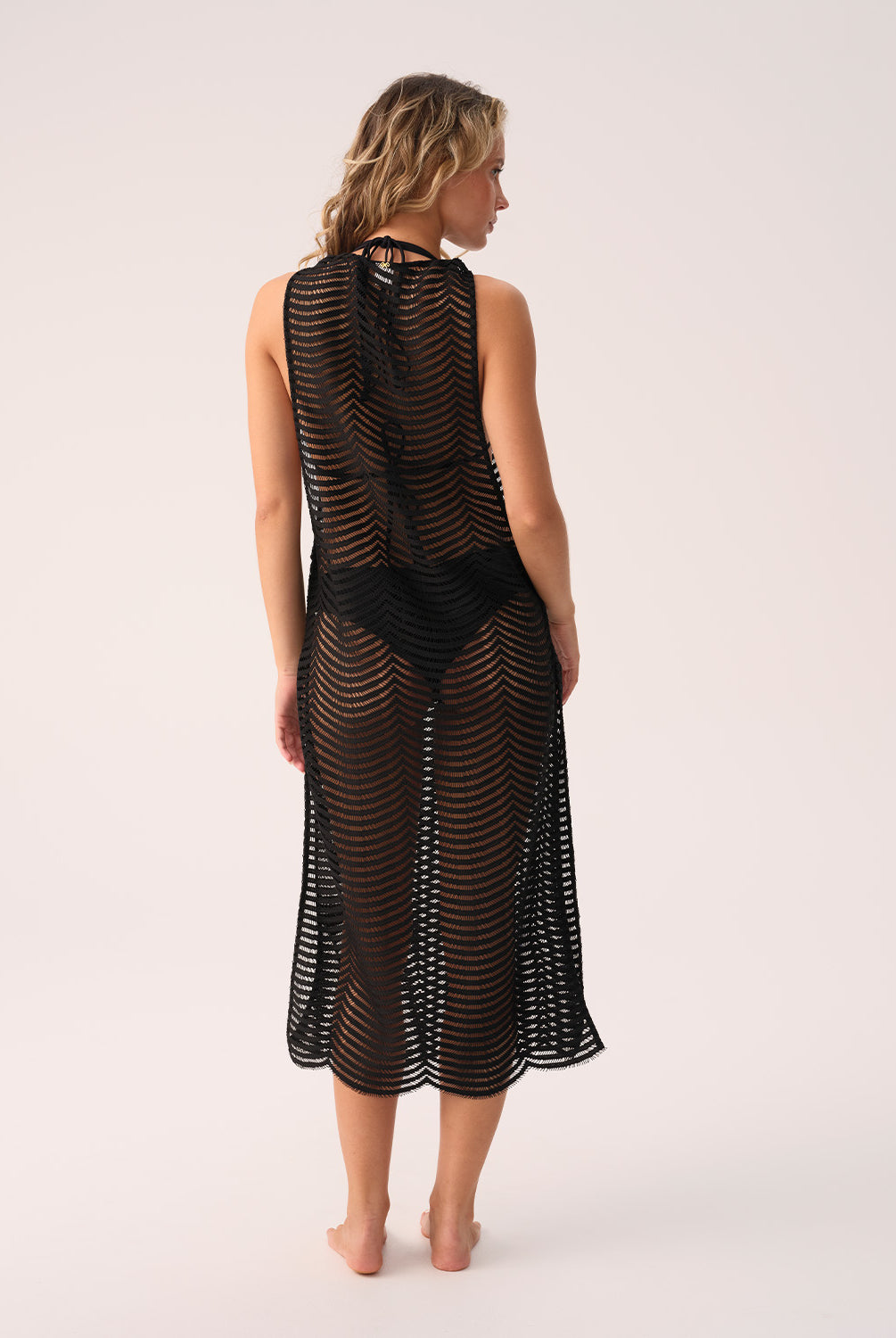 Woman wearing a black mesh dress on a white background