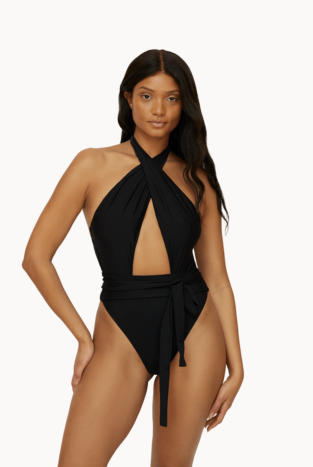 Woman wearing a black one piece in front of a white background.