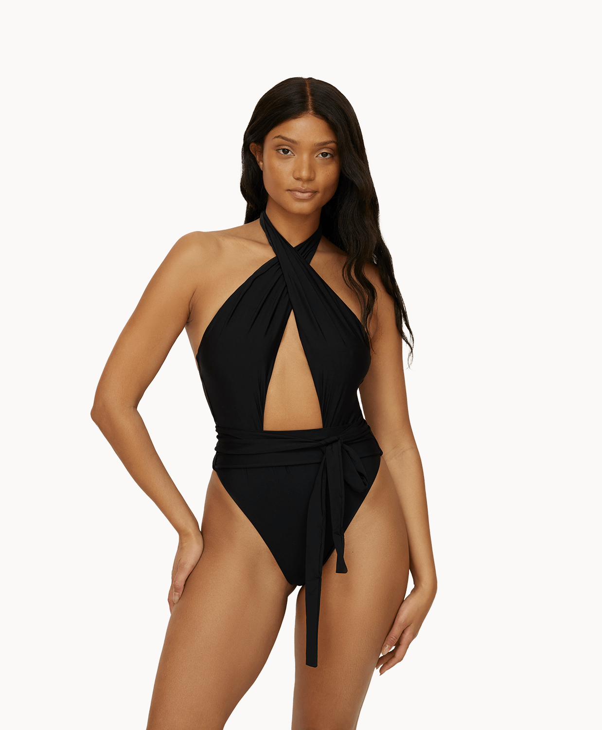 Woman wearing a black one piece in front of a white background.