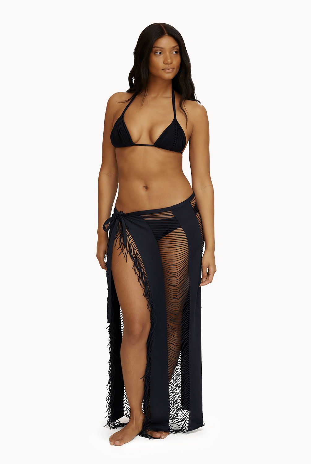 Woman wearing black sarong in front of a white background.