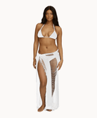 Woman wearing white sarong in front of a white background.
