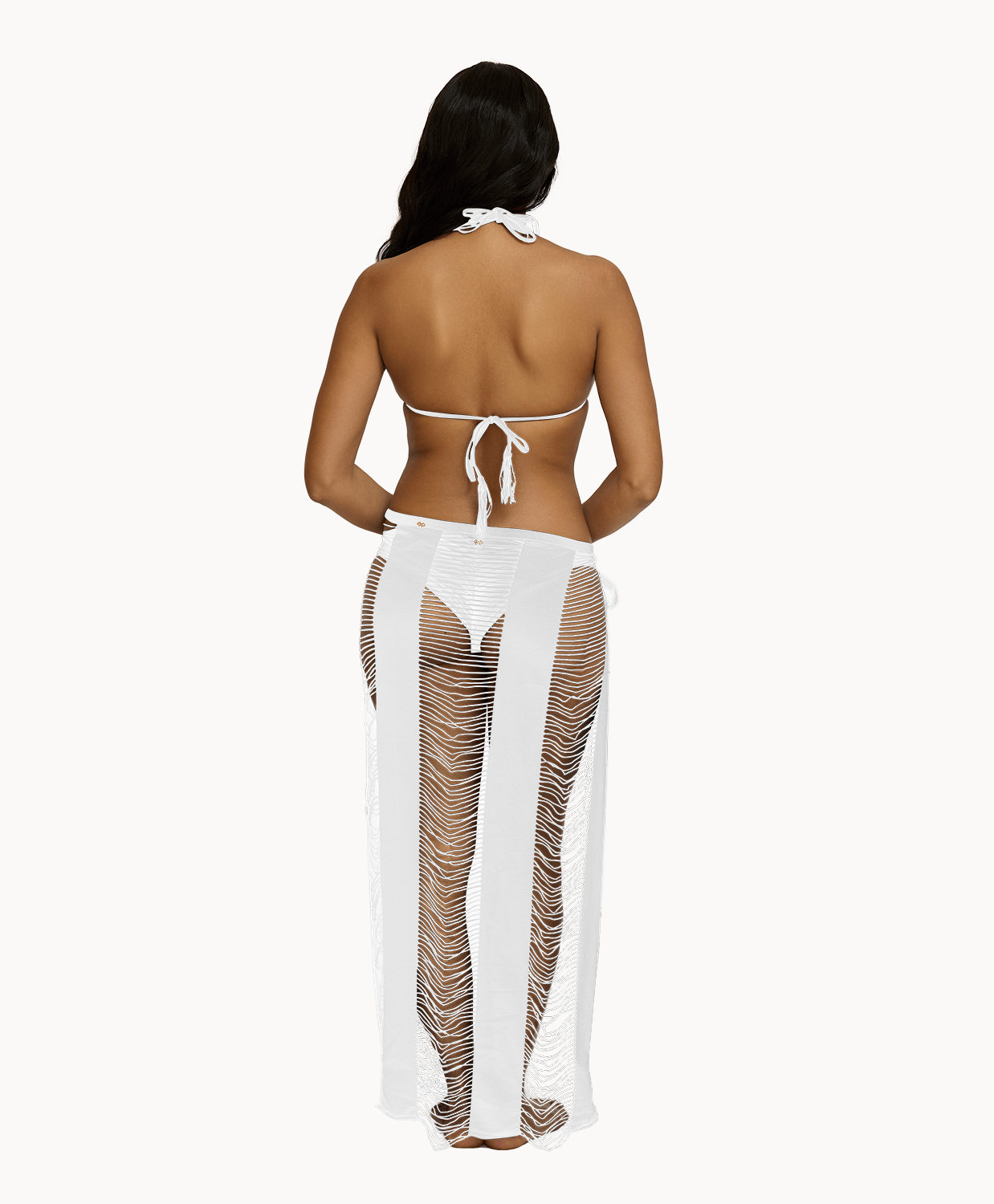 Back view of woman wearing white sarong in front of a white background.