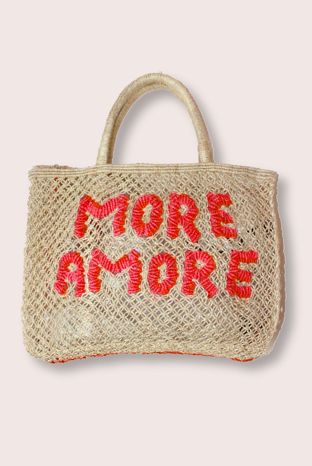 A purse/tote that says "More Amore" in pink letters against a white wall.