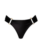 A black bikini bottom against a white wall.