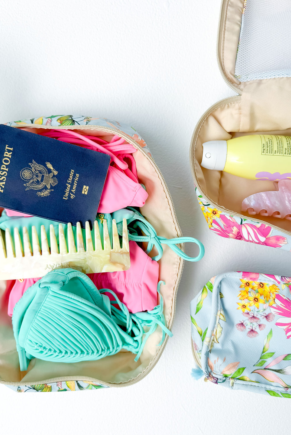 Three packing cubes with travel essentials packed inside.