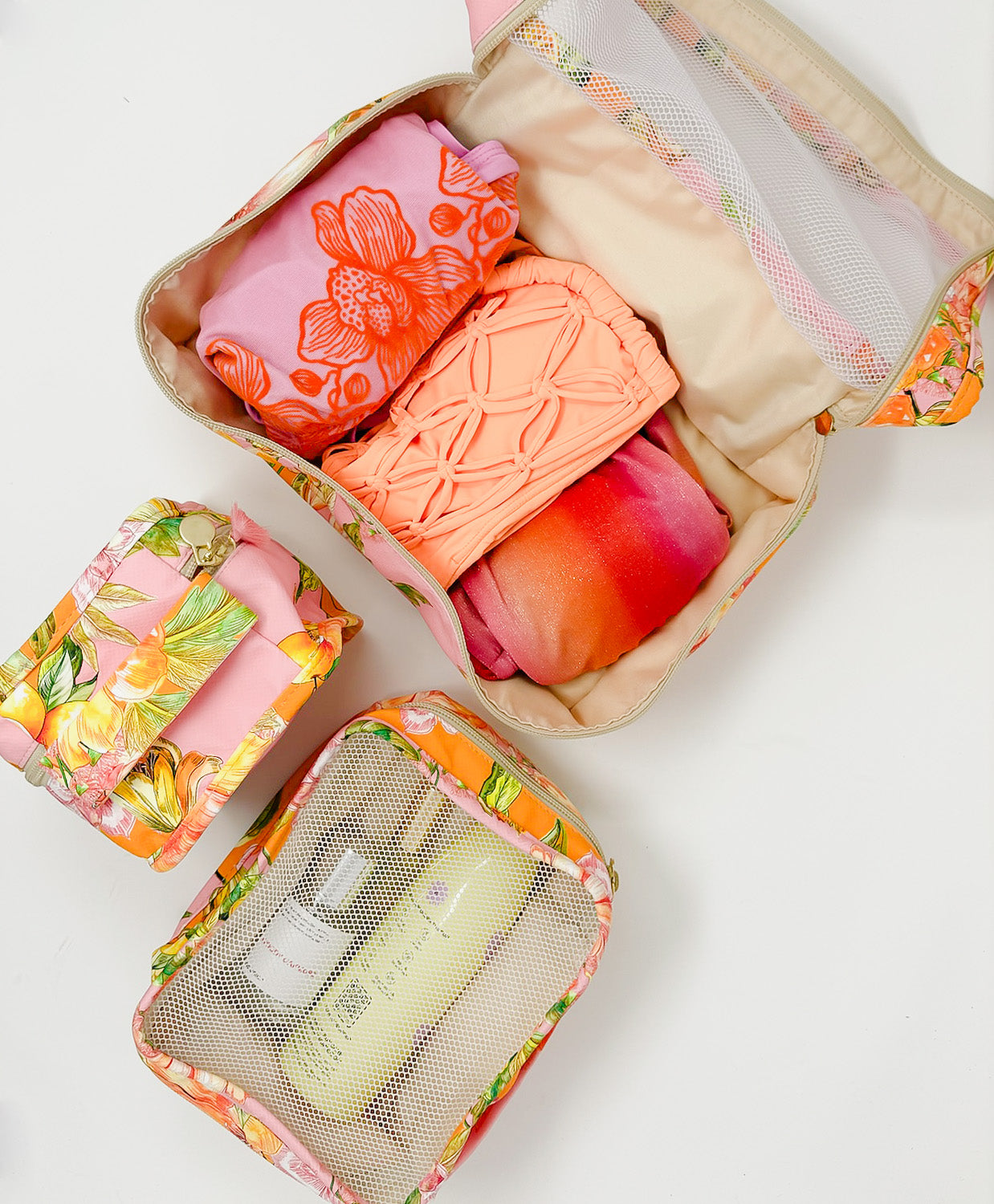 Three packing cubes with travel essentials packed inside.