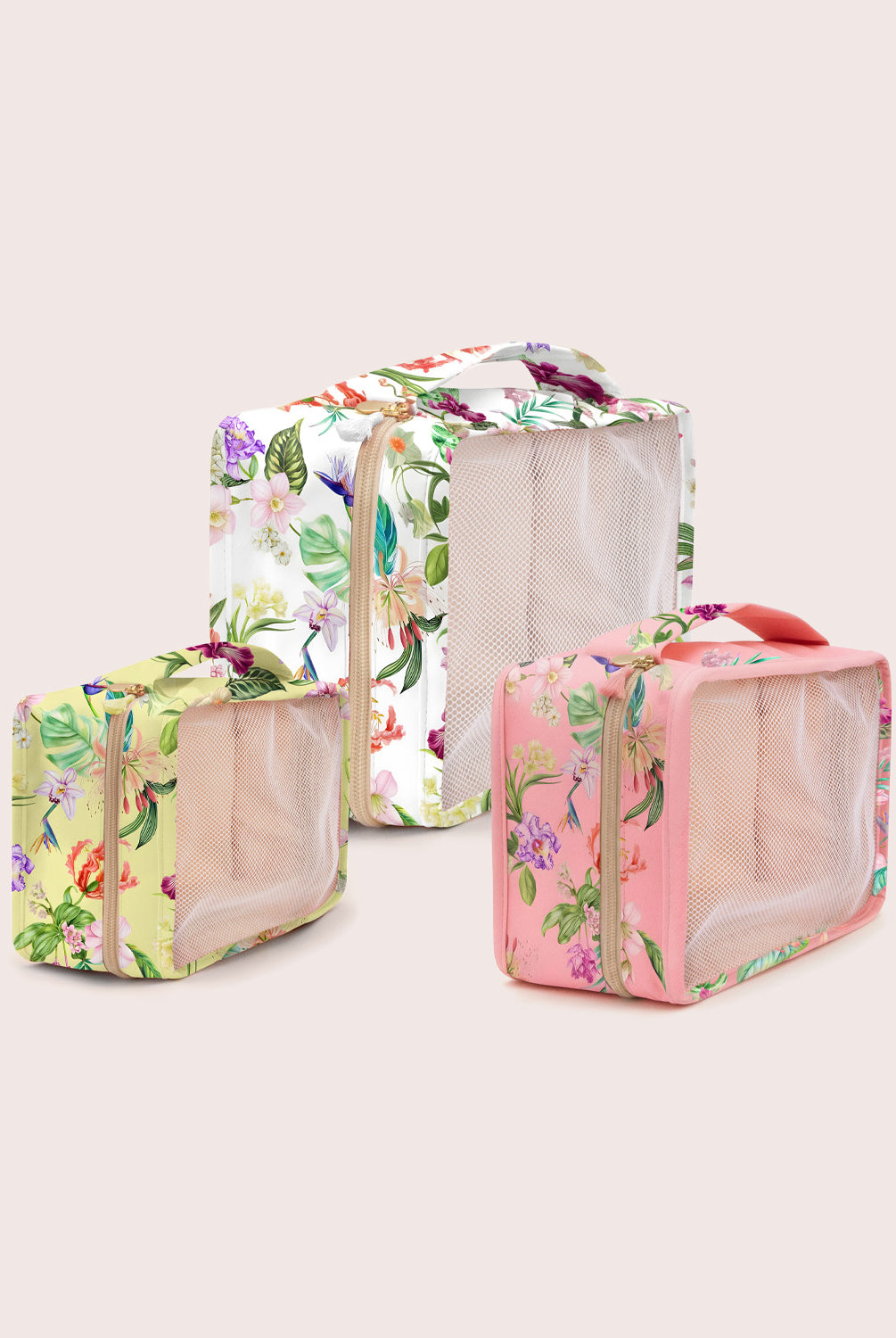Set of three floral-patterned travel bags on a light beige background