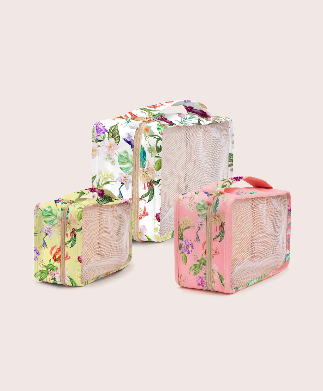 Set of three floral-patterned travel bags on a light beige background